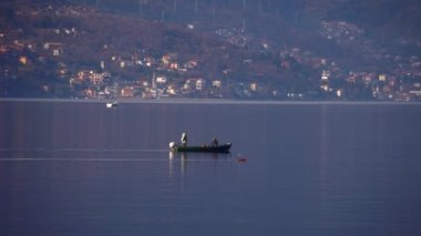 Como Gölü, İtalya. Balıkçılar gölde bir kayıkla yelken açarlar. Avrupa 'nın en büyük gölü. Yerel bir İtalyan restoranı için tatlı su gölünden taze balık. Doğa. Akşam vakti. Sakin su