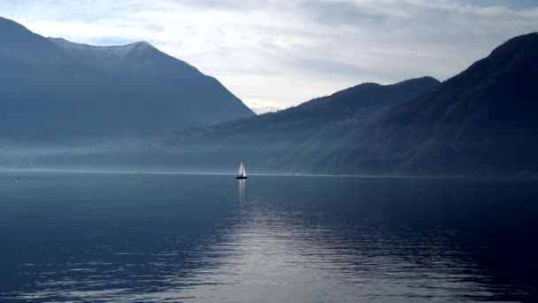 意大利的科莫湖日落时乘坐帆船旅行 电影全景 在青山的背景下 豪华游艇探险与恋人在一起 浪漫的旅行 — 图库视频影像