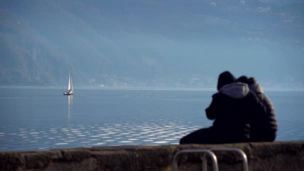 意大利的科莫湖日落时乘坐帆船旅行 电影全景 在青山的背景下 豪华游艇探险与恋人在一起 浪漫的旅行 — 图库视频影像