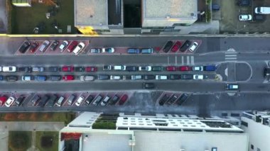 Milan İtalya Havayolları akşamları Milano 'da araba sürerken tepeden aşağı bakıyor. İHA tepeden tırnağa uçuyor, cadde boyunca park etmiş arabaları vuruyor.