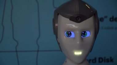 Robot duygularını gösteriyor. Yapay Zeka. Modern robotik. Robot insanlara bakıp gülümsüyor. Robotun gözleri. Sayborg. Robot kameraya bir insana bakıyor. Akıllı bilgisayar. Geleceğe. Çocuklar için harika bir oyuncak..