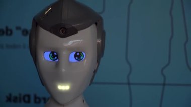 Robot duygularını gösteriyor. Yapay Zeka. Modern robotik. Robot insanlara bakıp gülümsüyor. Robotun gözleri. Sayborg. Robot kameraya bir insana bakıyor. Akıllı bilgisayar. Geleceğe. Çocuklar için harika bir oyuncak..