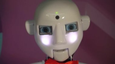 Robot duygularını gösteriyor. Yapay Zeka. Modern robotik. Robot insanlara bakıp gülümsüyor. Robotun gözleri. Sayborg. Robot kameraya bir insana bakıyor. Akıllı bilgisayar. Geleceğe. Çocuklar için harika bir oyuncak..
