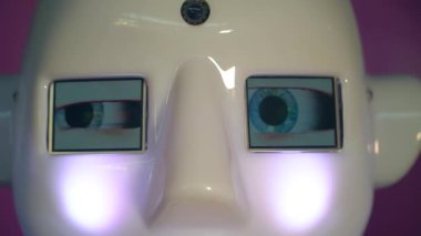 Robot duygularını gösteriyor. Yapay Zeka. Modern robotik. Robot insanlara bakıp gülümsüyor. Robotun gözleri. Sayborg. Robot kameraya bir insana bakıyor. Akıllı bilgisayar. Geleceğe. Çocuklar için harika bir oyuncak..