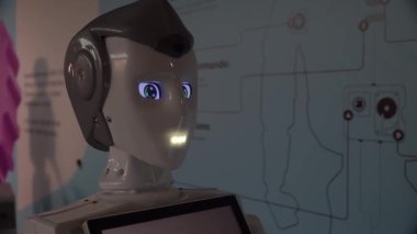 Robot duygularını gösteriyor. Yapay Zeka. Modern robotik. Robot insanlara bakıp gülümsüyor. Robotun gözleri. Sayborg. Robot kameraya bir insana bakıyor. Akıllı bilgisayar. Geleceğe. Çocuklar için harika bir oyuncak..