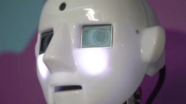 Robot duygularını gösteriyor. Yapay Zeka. Modern robotik. Robot insanlara bakıp gülümsüyor. Robotun gözleri. Sayborg. Robot kameraya bir insana bakıyor. Akıllı bilgisayar. Geleceğe. Çocuklar için harika bir oyuncak..