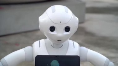 Milan, İtalya: bir robot şehrin sokaklarında yürüyor. İnsanlar robotun fotoğraflarını çekiyor. Yapay Zeka. Modern robot teknolojisi. Çocuklar için harika bir oyuncak. Duygularını gösteriyor. Robot bizon boyunca karşıdan karşıya geçer. Gelecek. 