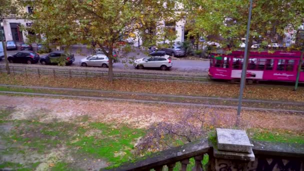 ミラノ イタリア2020年3月11日 古い黄色のトラムの交通 イタリアのファッションの街で秋の朝 市内の秋の木 特徴的な路面電車と木が並ぶ街の路地 公共交通機関 — ストック動画