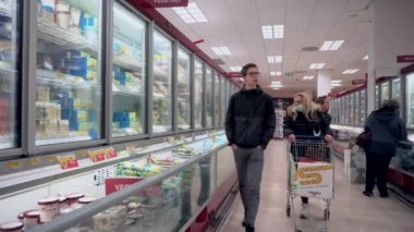 Milan, İtalya - 17 Mart 2020: Market veya süpermarket. Maskeli insanlar yiyecek alır. Virüsün tacından karantina. Kapalı şehir. Ürünlerle dolu raflar. Beslenme.