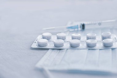 Coronavirus 'a karşı korunmak için tıbbi maskeler, parasetomol ve şırınga. Tıbbi solunum bandajı yüz ve parasetomol. COVID-19 virüsünün yayılmasının önlenmesi