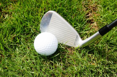 Golf topu ve golf demir yeşil çimenlerin üzerinde
