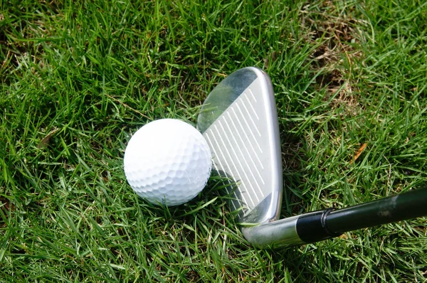 Golfboll och golf järn på grönt gräs — Stockfoto