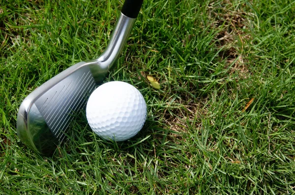 Golfboll och golf järn på grönt gräs — Stockfoto