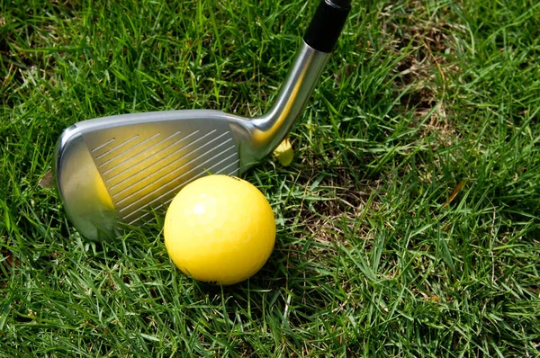 Bola de golfe e ferro de golfe na grama verde — Fotografia de Stock
