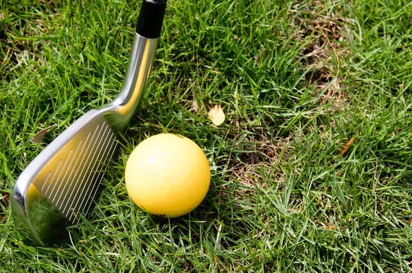 Bola de golfe e ferro de golfe na grama verde — Fotografia de Stock