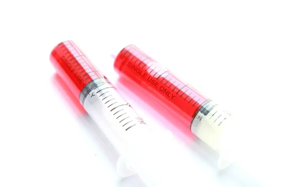 与孤立的白色背景上的红色液体注射器 — 图库照片