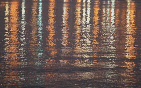 Abstract lights reflecting on the water at twilight time — Stock Photo, Image