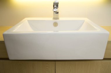 Beyaz porselen s üzerinde modern paslanmaz çelik musluk Close-Up