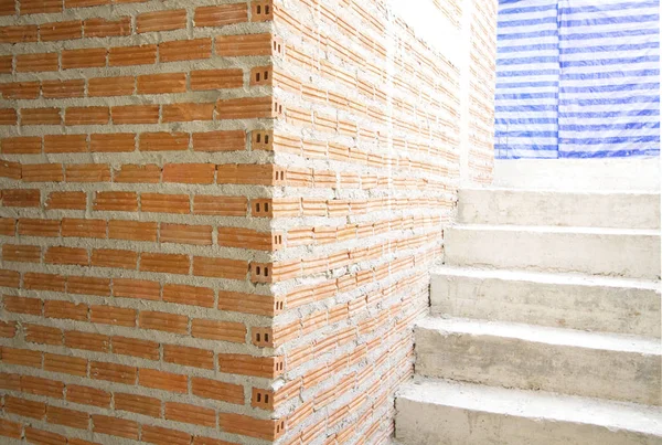 Casa em construção com parede de tijolo vermelho e escada — Fotografia de Stock