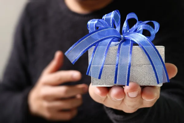 Cadeau, la main de l'homme tenant une boîte cadeau dans un geste de giving.b — Photo