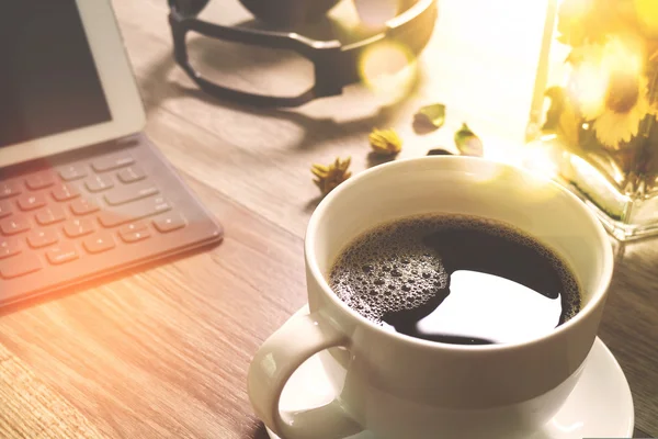 Koffiekopje en digitale tabel dock slimme toetsenbord, vaas bloem haar — Stockfoto