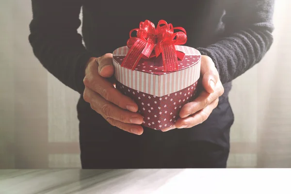 Regalo, mano de hombre sosteniendo una caja de regalo en un gesto de giving.b — Foto de Stock