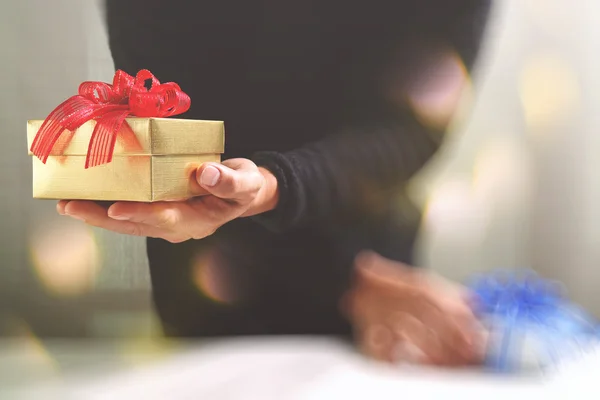 Regalo, mano de hombre sosteniendo una caja de regalo en un gesto de giving.b — Foto de Stock