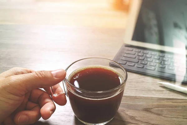 Ręka trzyma filiżanka kawy lub herbaty i Digital tabeli zadokować smart keyb — Zdjęcie stockowe