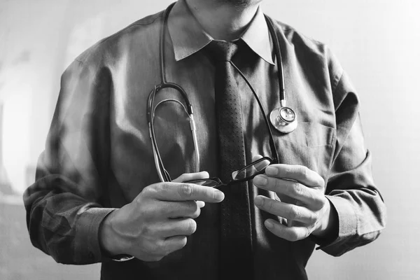 Smart medical doctor holding eyeglass,stethoscope ,front view,fi — Stock Photo, Image