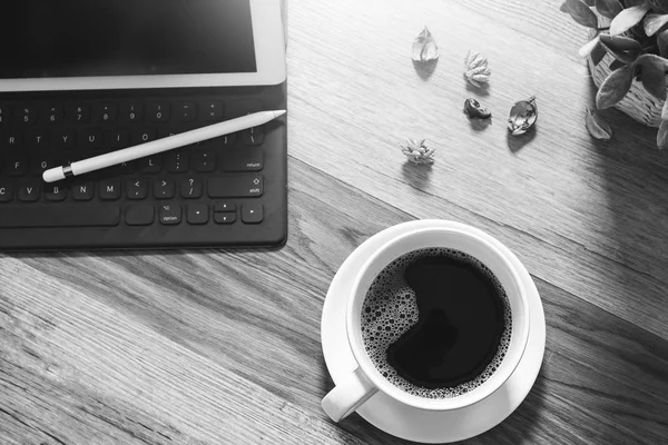 Koffiekopje en digitale tabel dock slimme toetsenbord, vaas bloem haar — Stockfoto