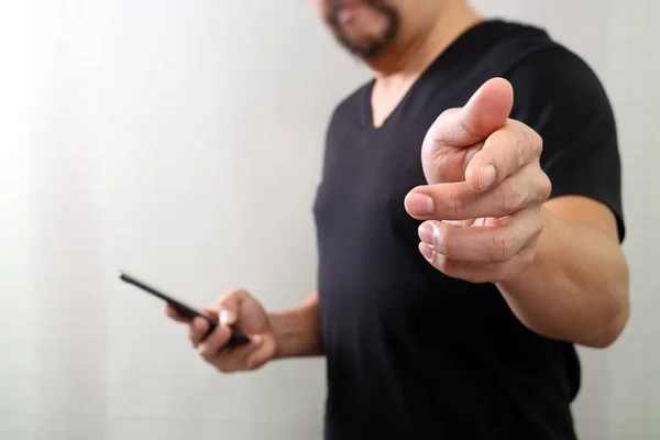 Designer mão pressionando um botão imaginário, segurando telefone inteligente, d — Fotografia de Stock