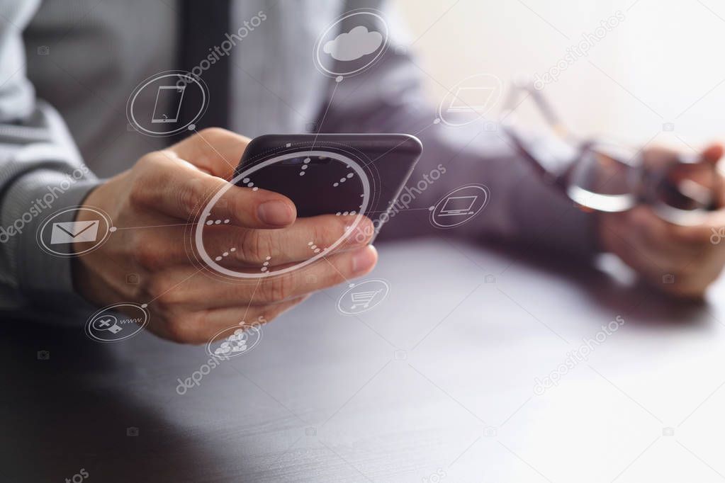 close up of businessman working with mobile phone and eyeglass o