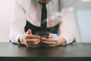 işadamı ile akıllı telefon ahşap masanın üzerinde çalışma yakın çekim 