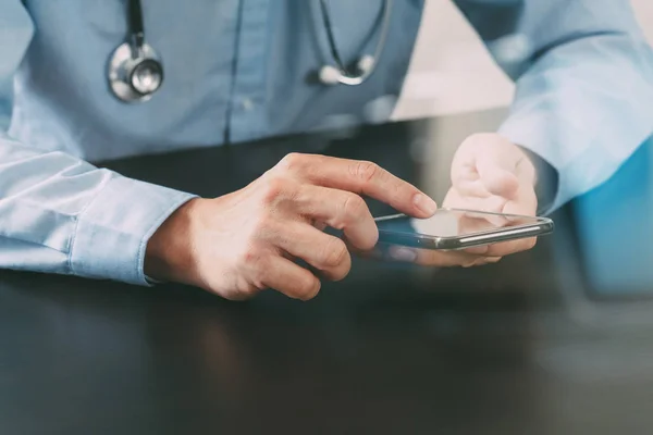 Primer plano del médico inteligente que trabaja con el teléfono inteligente y st — Foto de Stock