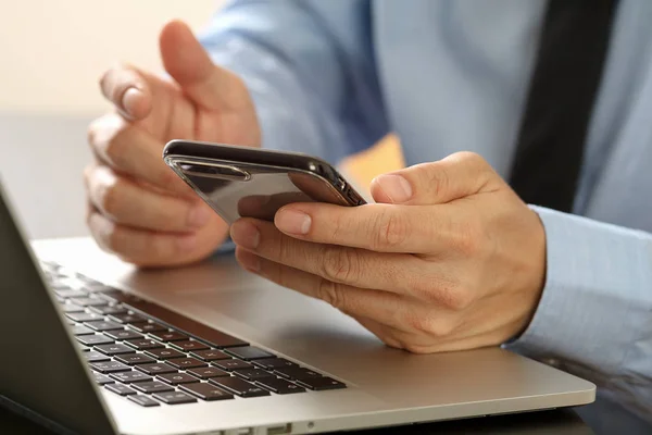 Primer plano del empresario que trabaja con el teléfono móvil y el ordenador portátil com — Foto de Stock