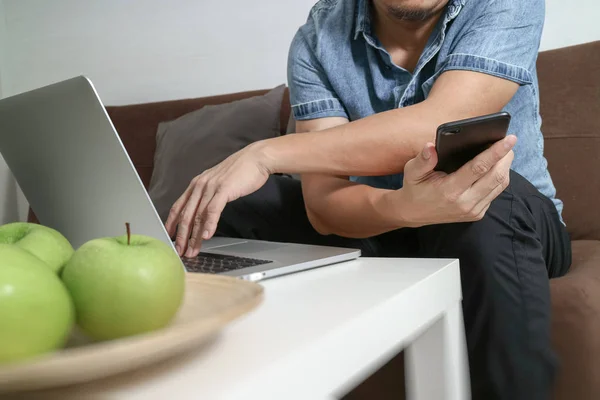 Návrháře muž ručně pomocí compter notebooku a mobilních plateb onlin — Stock fotografie