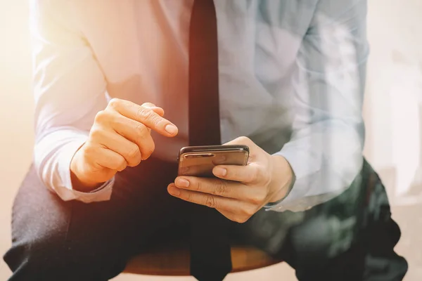 Close up de homem de negócios que trabalha com telefone celular e sentado em — Fotografia de Stock