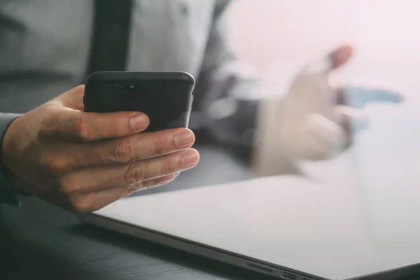 Primer plano del empresario que trabaja con el teléfono móvil y el ordenador portátil com — Foto de Stock