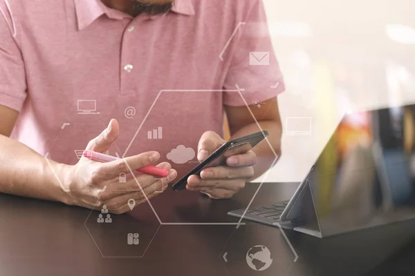 Geschäftsmann im rosafarbenen T-Shirt arbeitet mit Smartphone und Digitalkamera — Stockfoto