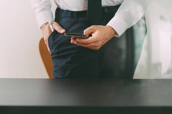 Close-up de homem de negócios trabalhando com telefone inteligente na mesa de madeira — Fotografia de Stock