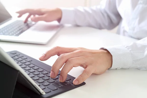 Gros plan de l'homme d'affaires tapant clavier avec ordinateur portable et — Photo