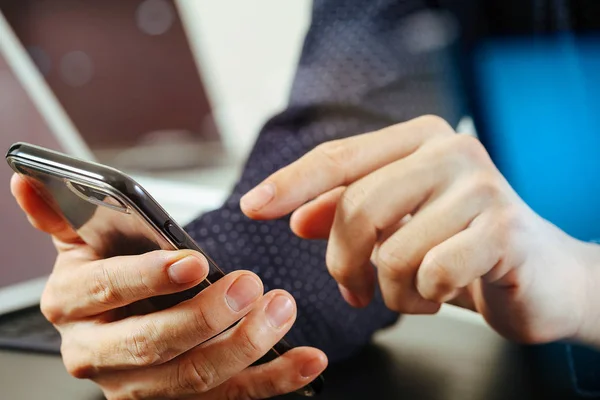 Närbild av affärsmannen hand arbetar med mobiltelefon och bärb — Stockfoto