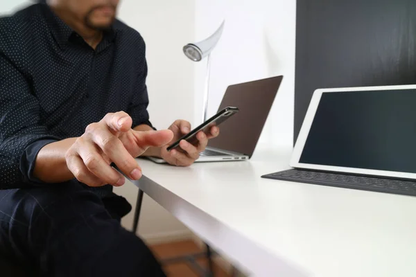 Hombre de negocios que trabaja con el teléfono inteligente y tableta digital y lapt — Foto de Stock