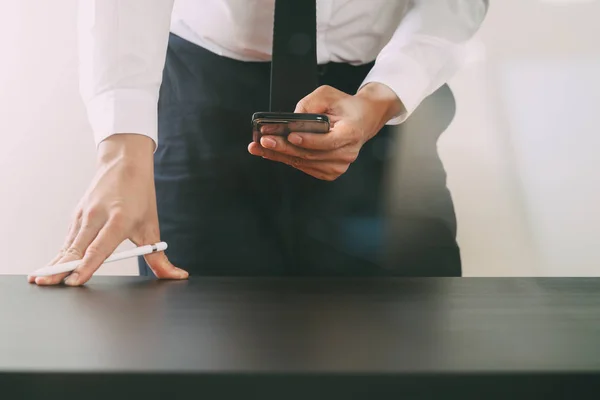 Primer plano del empresario que trabaja con el teléfono inteligente en el escritorio de madera — Foto de Stock