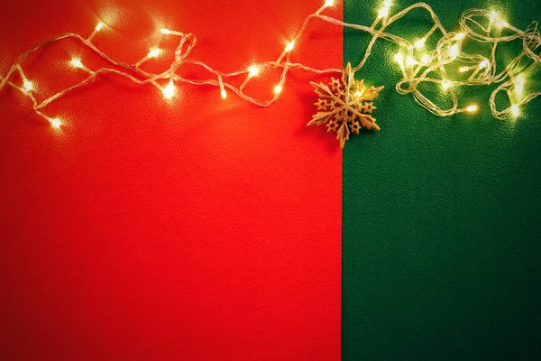 Concepto de la temporada de saludos. Luz de Navidad y estrella de pino en rojo y — Foto de Stock