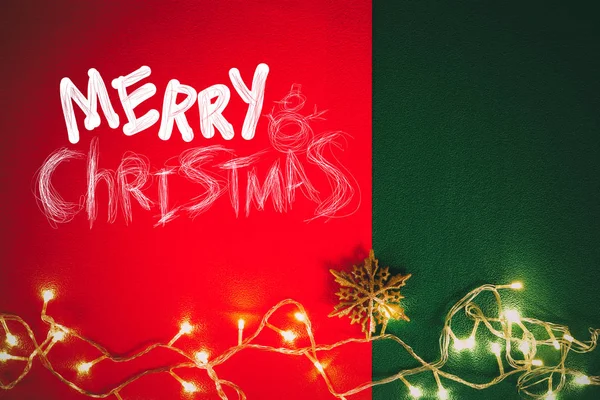 Concepto de la temporada de saludos. Luz de Navidad y estrella de pino en rojo y —  Fotos de Stock