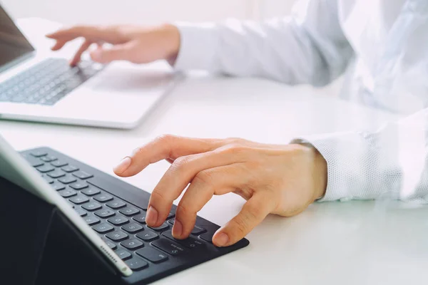 Primer plano del hombre de negocios tecleo teclado con ordenador portátil y —  Fotos de Stock