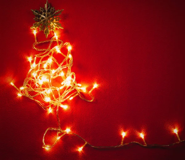 Groet seizoen concept. Kerstmis licht en pine ster op rode en — Stockfoto