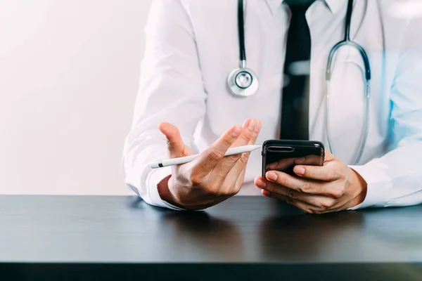 Close up de médico inteligente que trabalha com telefone inteligente e st — Fotografia de Stock