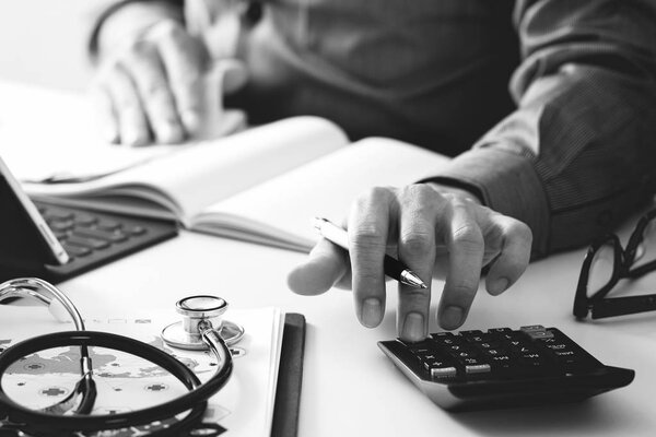Healthcare costs and fees concept.Hand of smart doctor used a ca